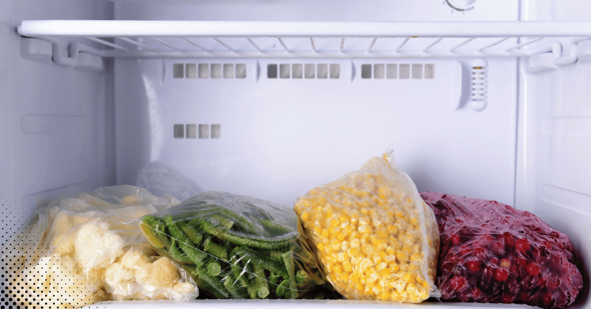 Frozen vegetables stored in clear bags inside a freezer.