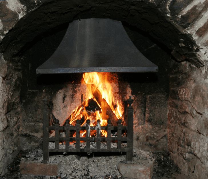 Traditional stone fireplace with a roaring fire inside