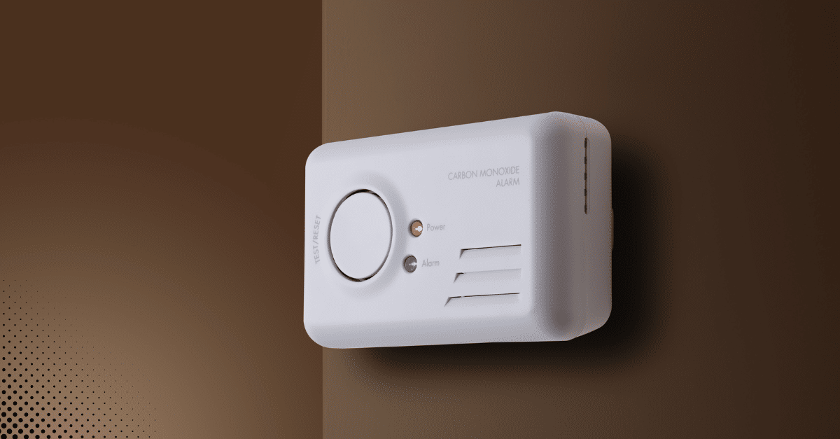 Carbon monoxide alarm mounted on a wall with power and alarm indicators.