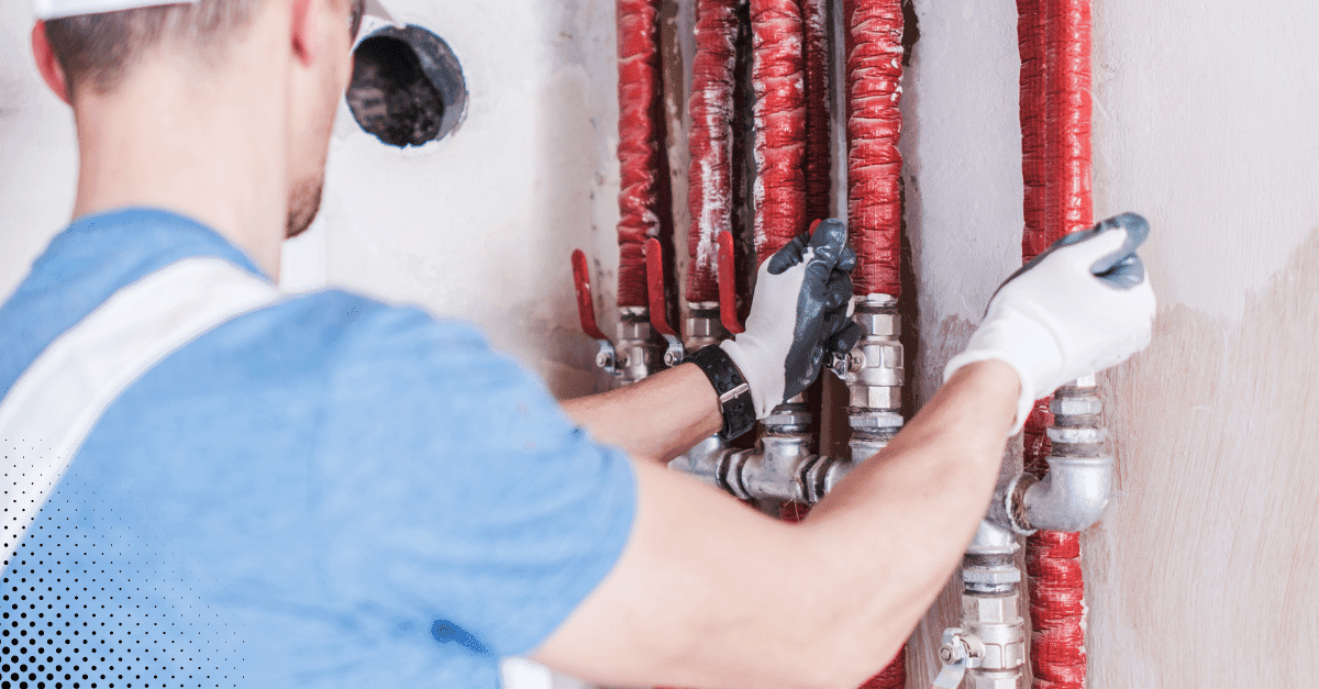 Inspector reviewing residential plumbing manifold and water supply lines.