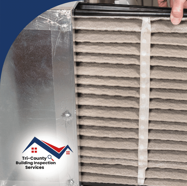Inspector reviewing a dirty HVAC air filter inside the system.